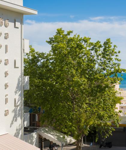 Hotel vicino al mare con spiaggia e alberi.