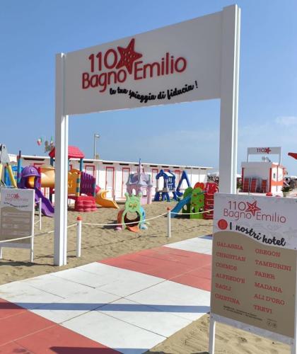 Spiaggia con giochi per bambini e cartello Bagno Emilio.